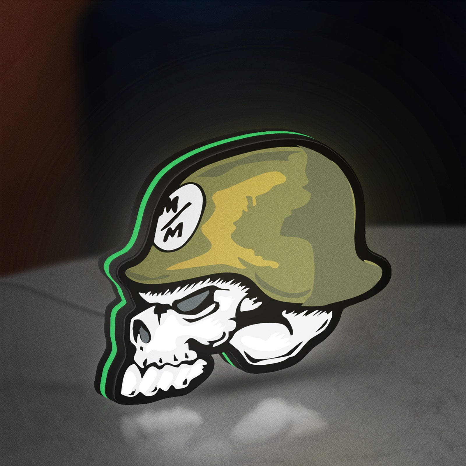 Metal Mulisha Skull LED lightbox standing on a desk from an angled side view with green glow