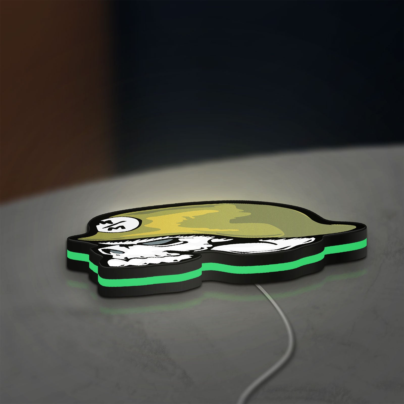 Metal Mulisha Skull LED lightbox lying flat on a desk with green glow