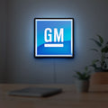 GM LED lightbox hanging on a room wall with soft blue light