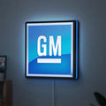 GM LED lightbox hanging on a wall with blue glow