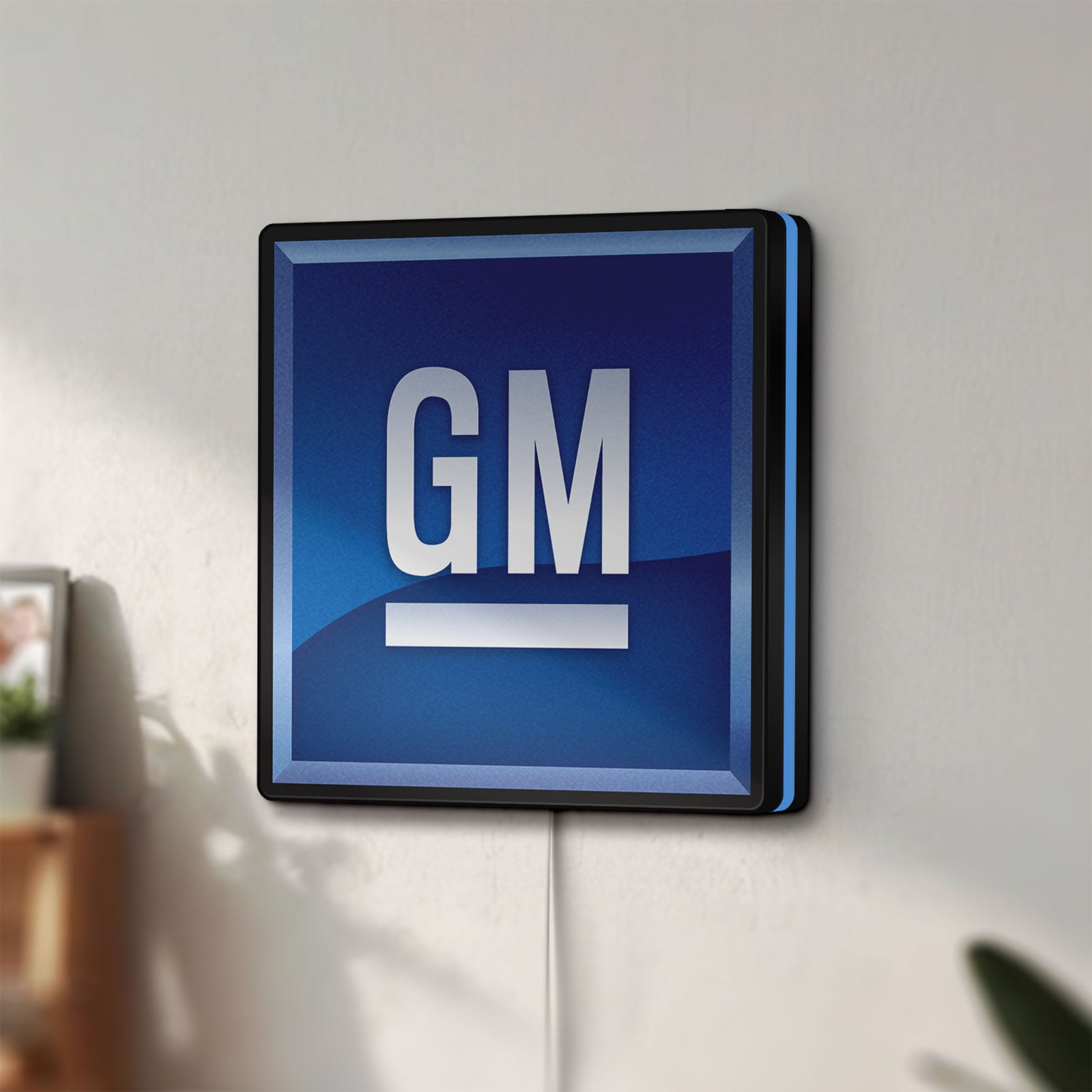 Unlit GM LED lightbox mounted on a wall in daylight