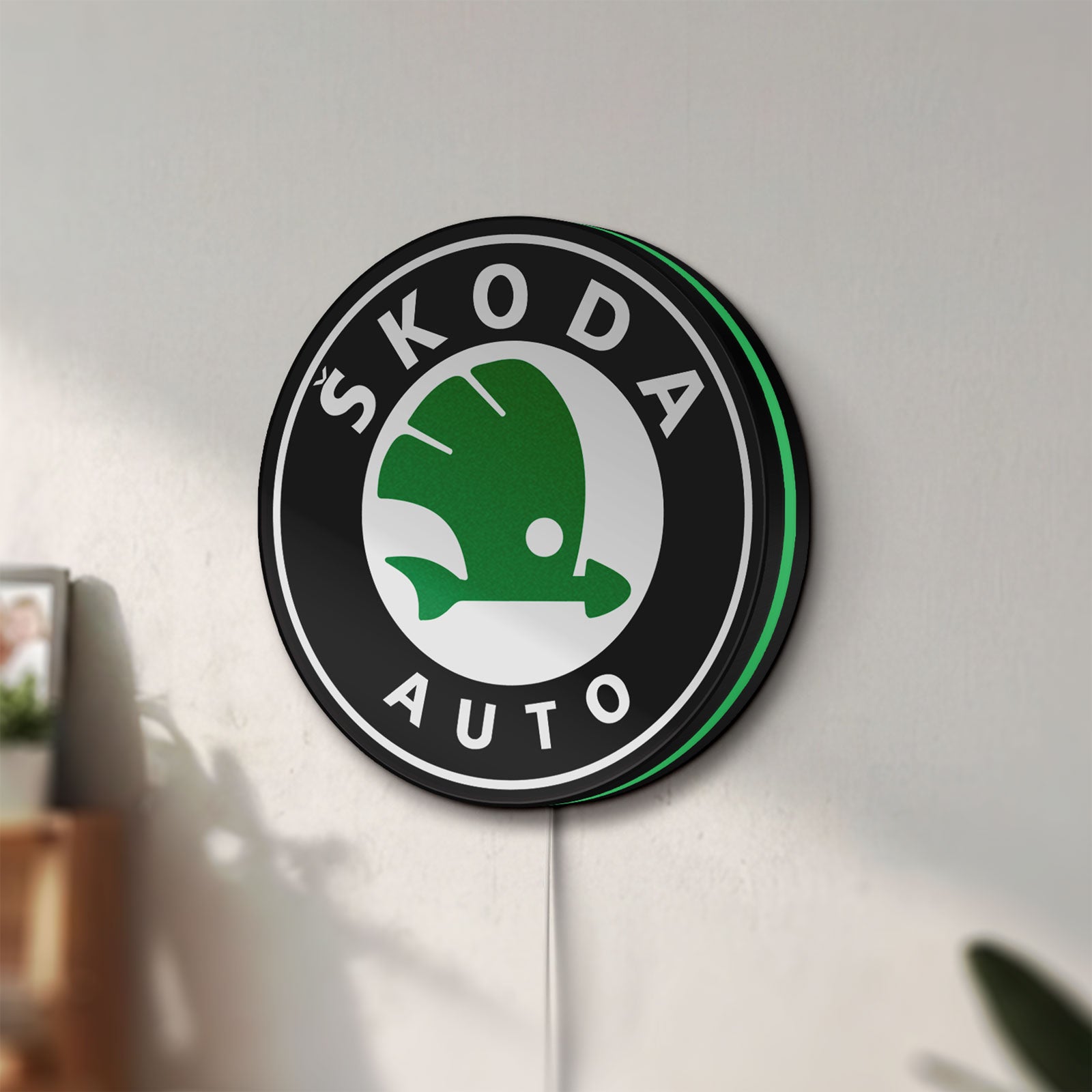 Unlit Skoda LED lightbox mounted on a wall in daylight