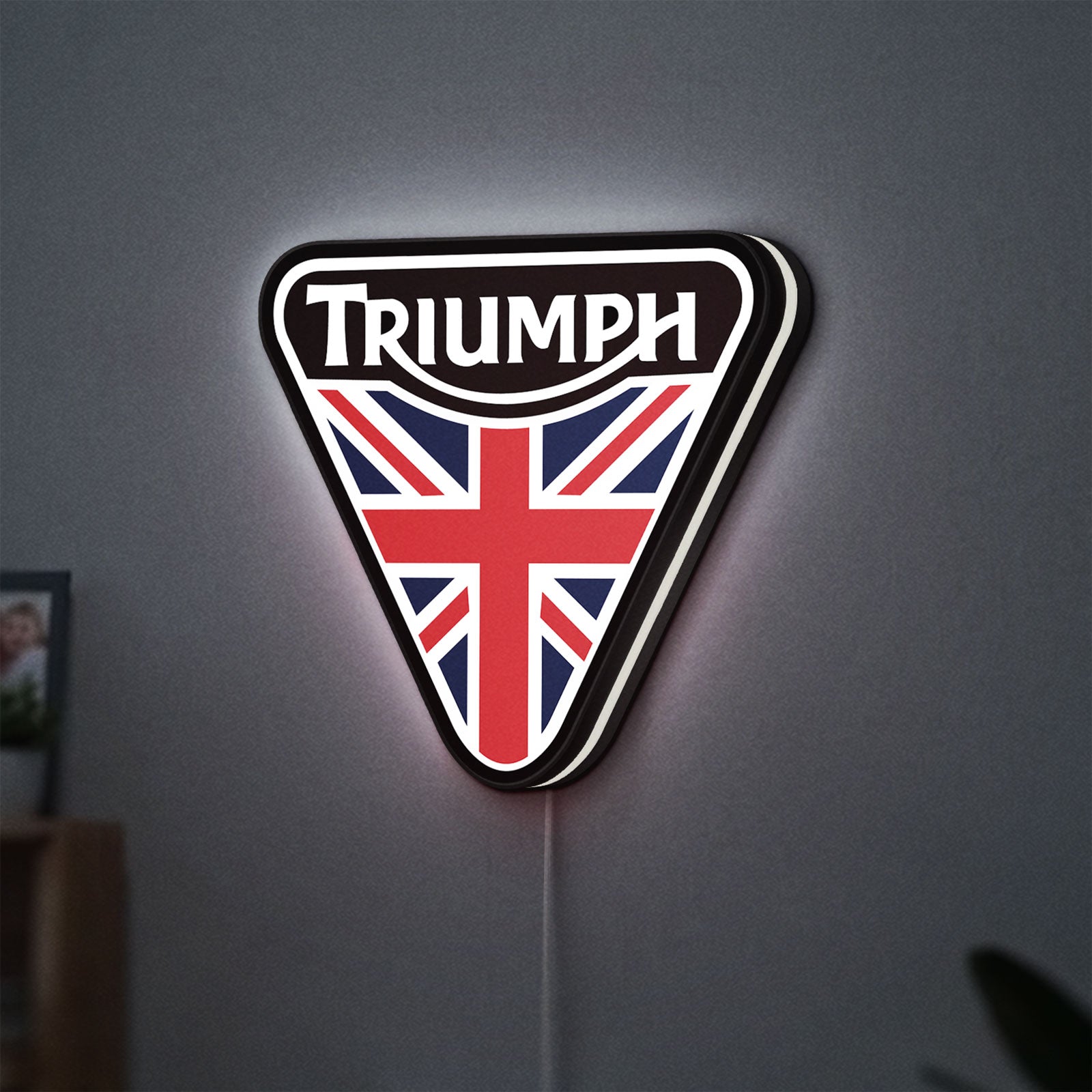 Triumph LED lightbox hanging on a wall with white glow