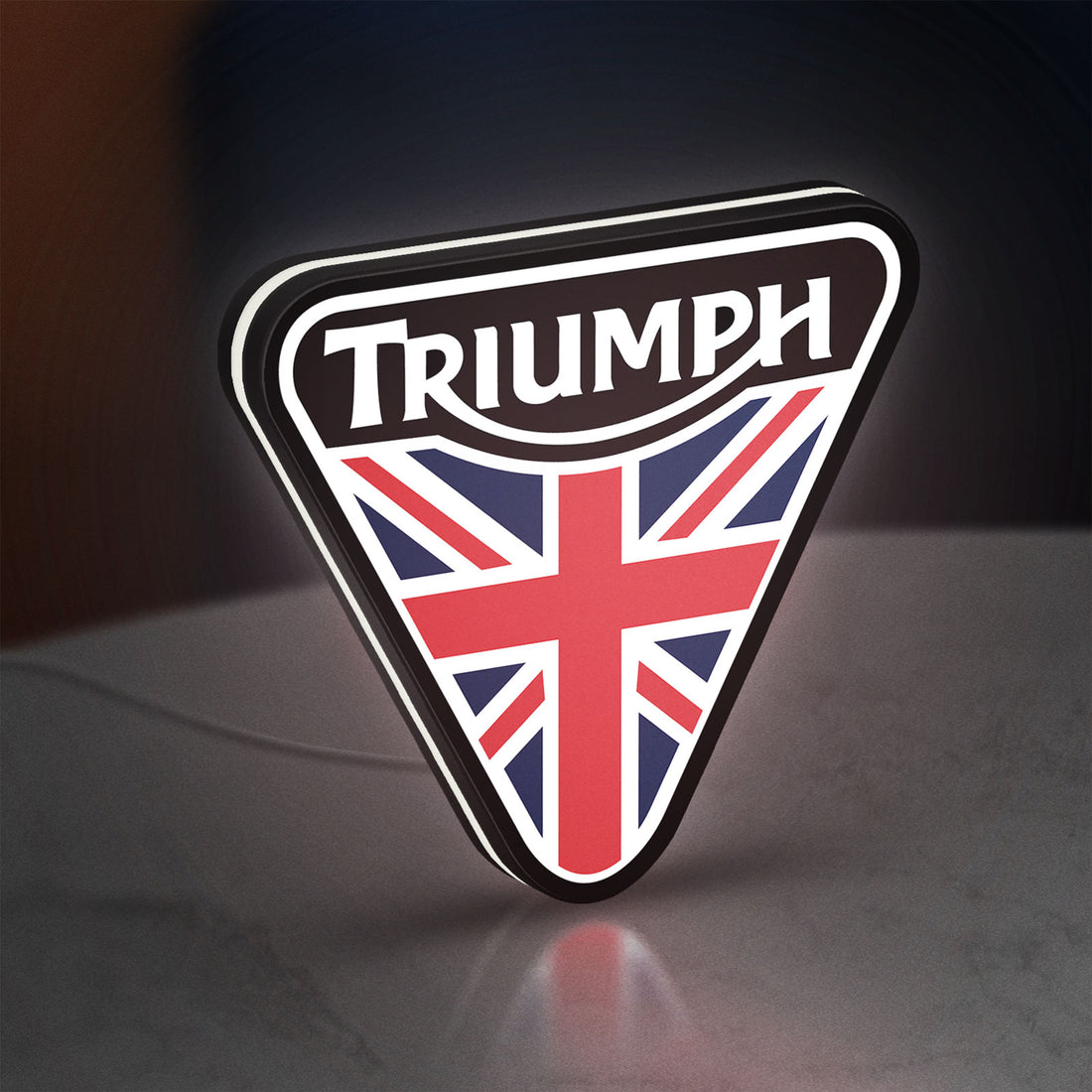 Triumph LED lightbox hanging on a wall with white glow