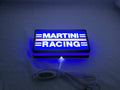 Illuminated flat lay angled view of Martini Racing 3D LED Sign in 20cm, perfect for garage and man cave decor