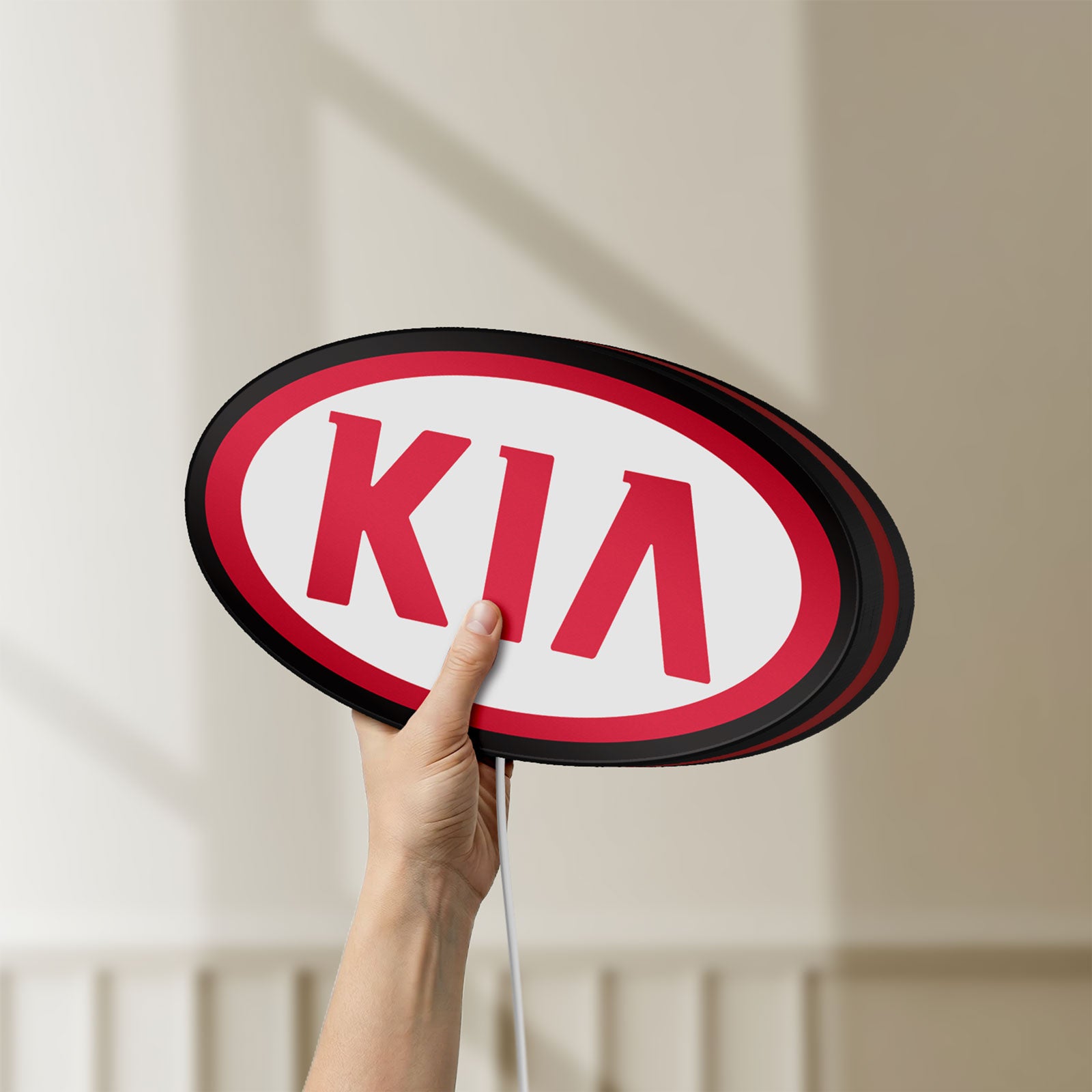 Unlit KIA LED lightbox held by hand to show size and details