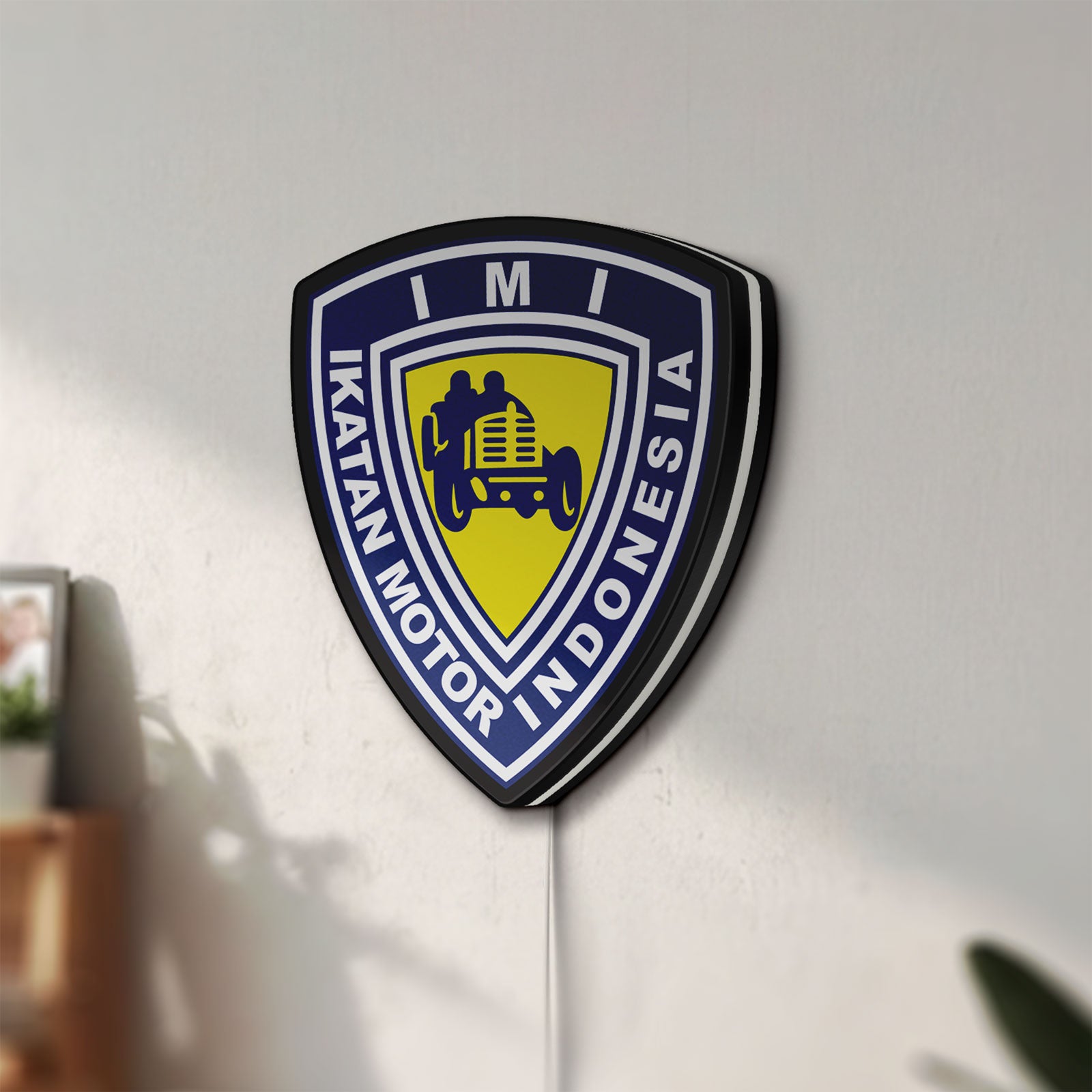 Unlit Ikatan Motor Indonesia LED lightbox mounted on a wall in daylight