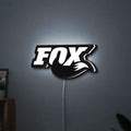 FOX Racing LED lightbox hanging on a wall with white glow