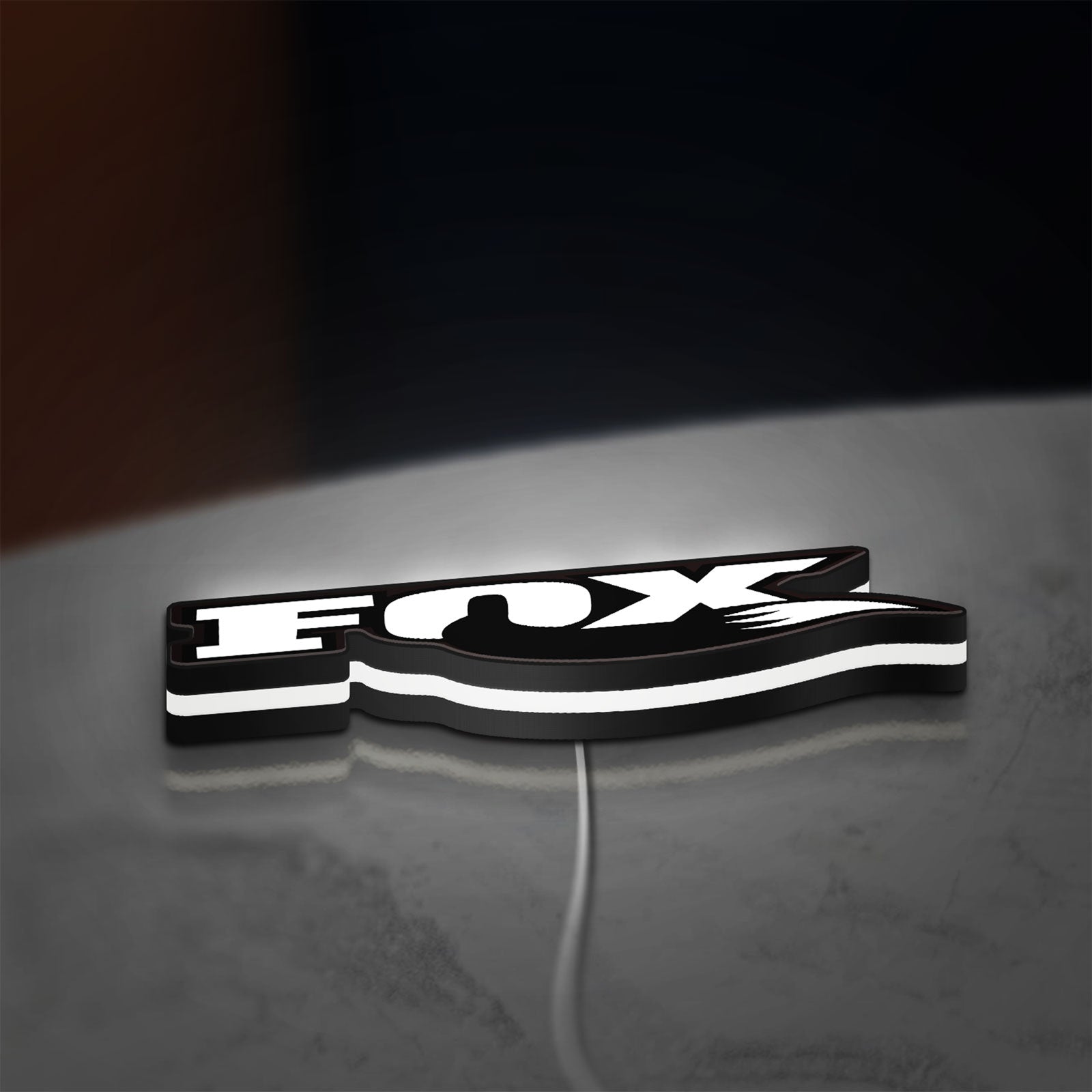 FOX Racing LED lightbox lying flat on a desk with white glow