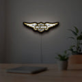 Harley Davidson Wings LED lightbox hanging on a room wall with soft yellow light