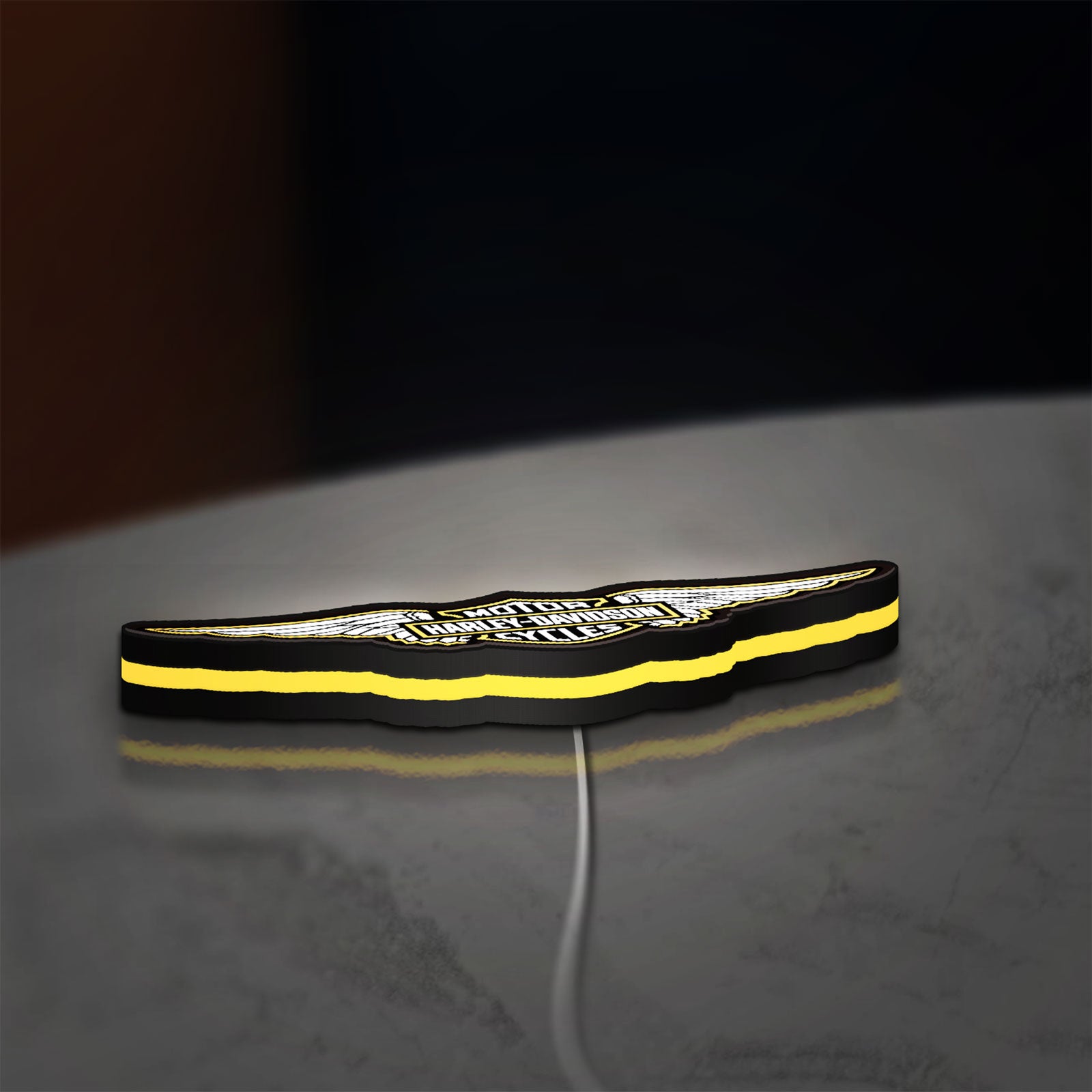 Harley Davidson Wings LED lightbox lying flat on a desk with yellow glow