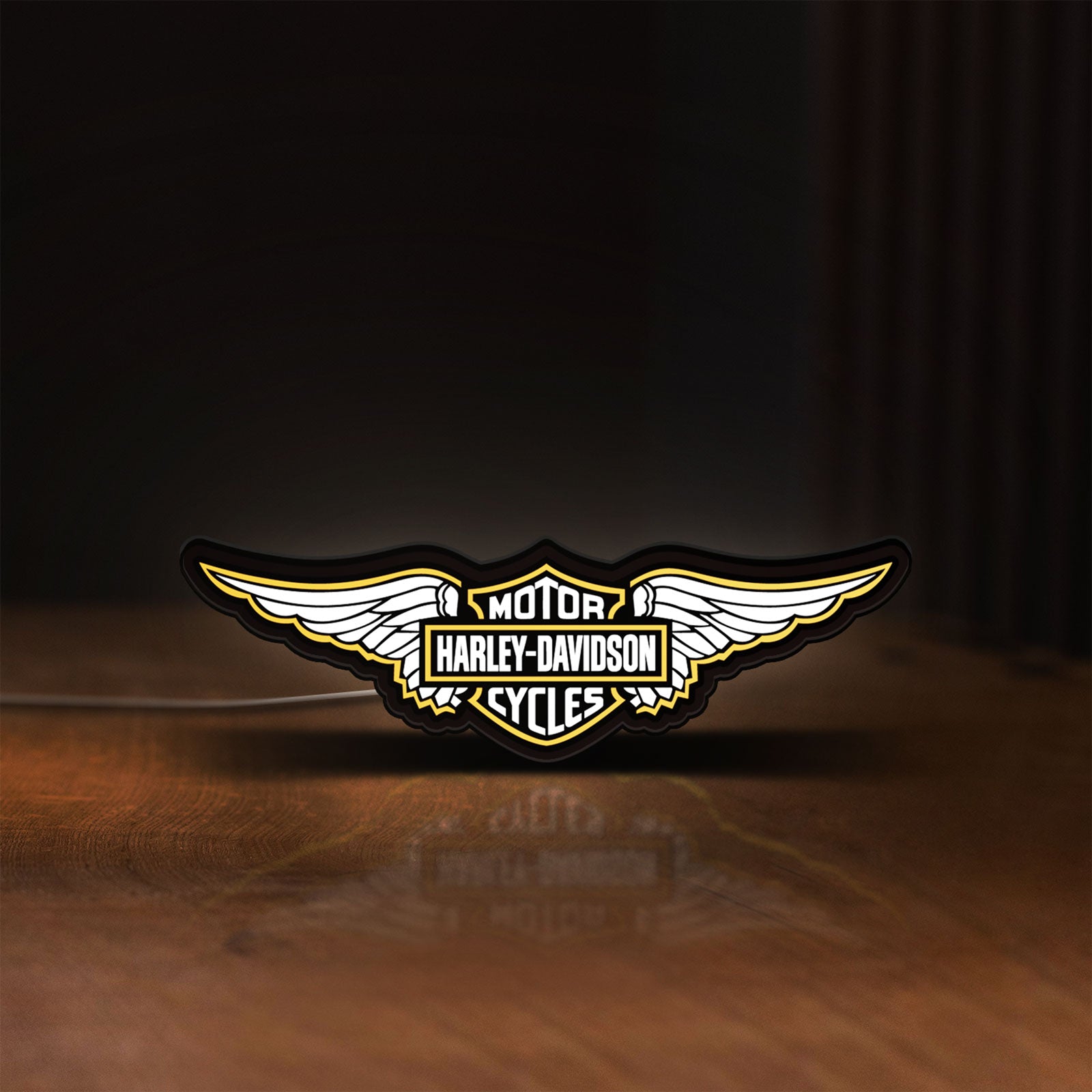 Front view of Harley Davidson Wings LED lightbox sign glowing on a wooden desk