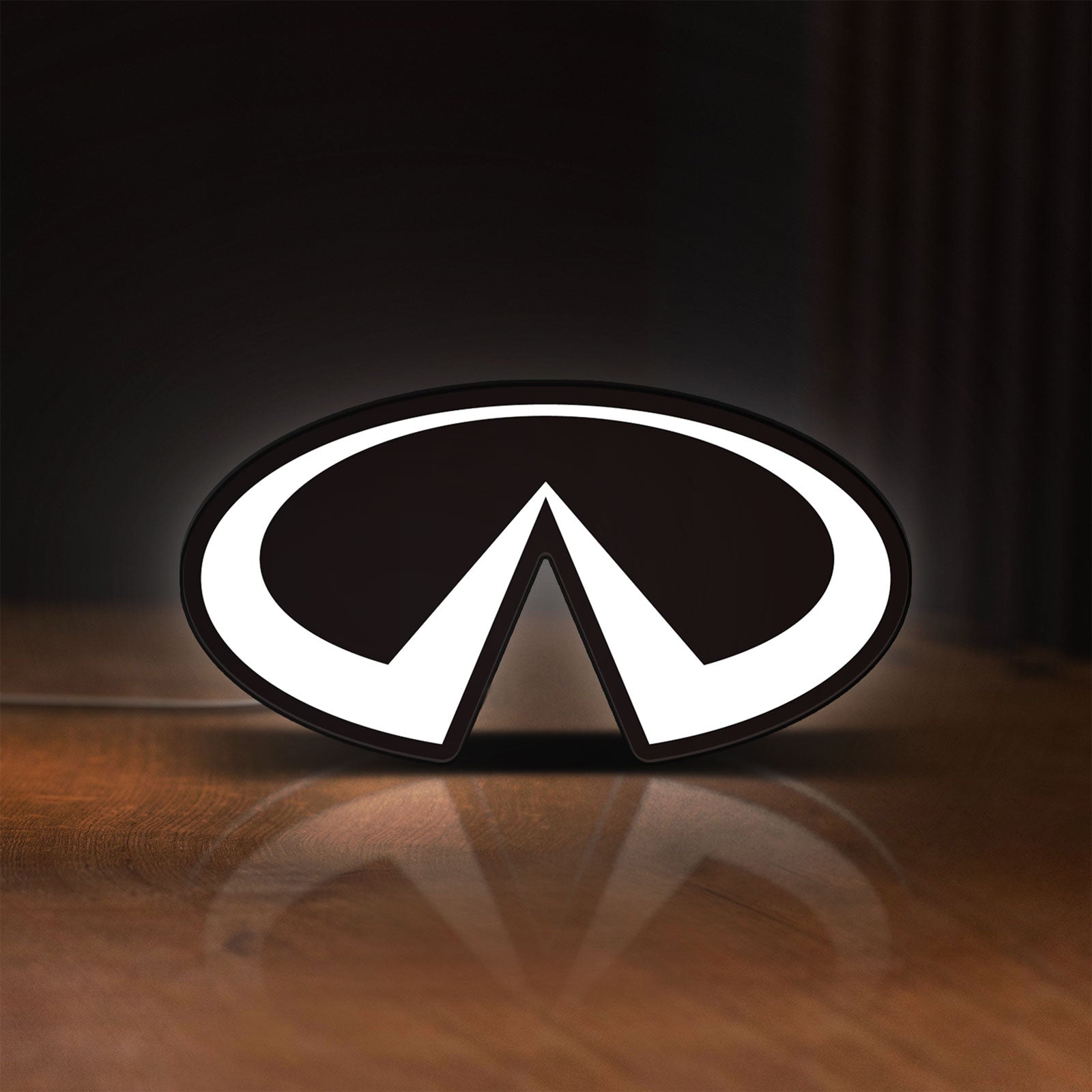 Front view of Infiniti LED lightbox sign glowing on a wooden desk