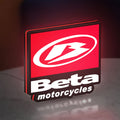 Beta Italian Motorcycles LED lightbox standing on a desk from an angled side view with red glow