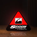 Front view of Spoon Sports LED lightbox sign glowing on a wooden desk