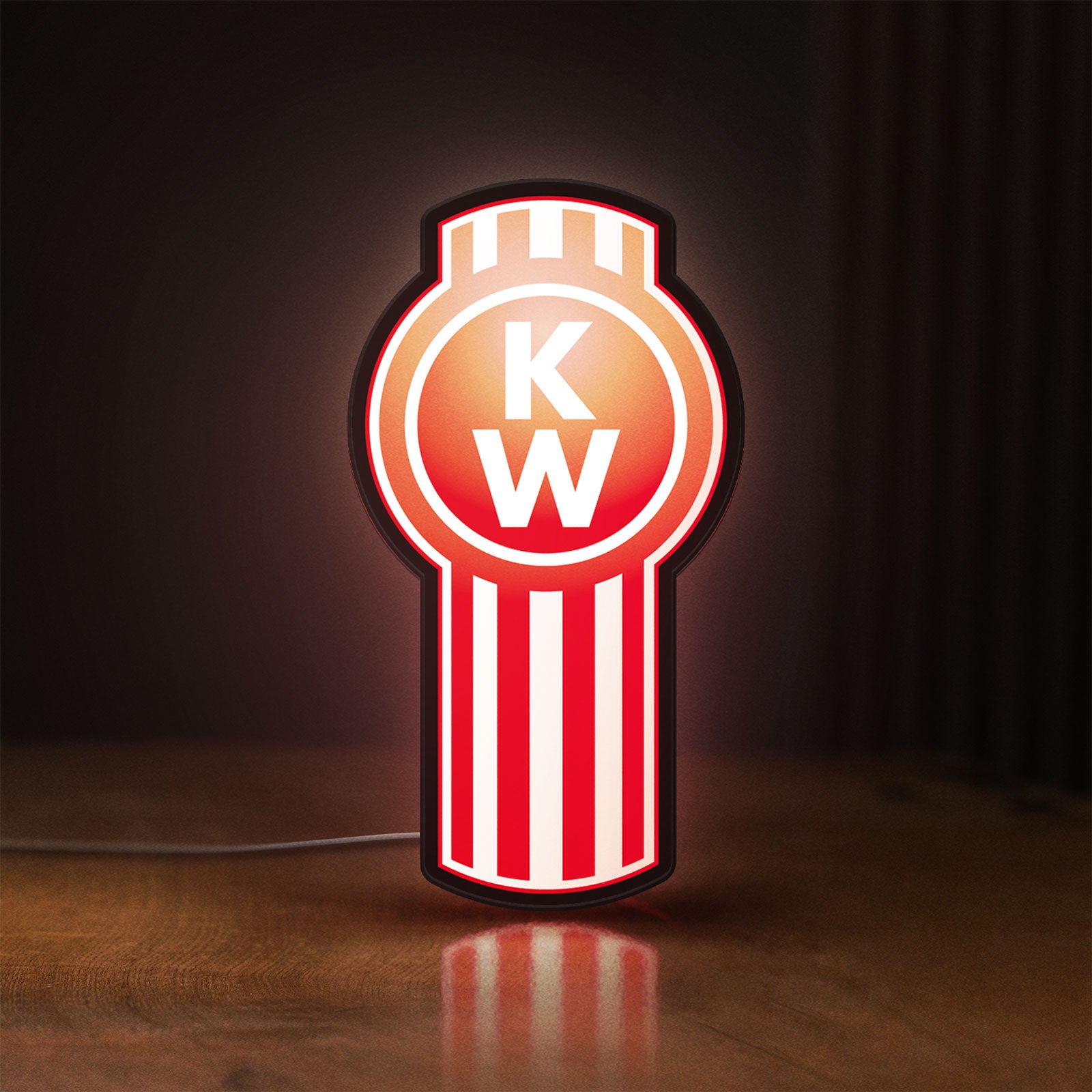 Front view of Kenworth LED lightbox sign glowing on a wooden desk