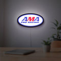 AMA Pro Racing LED lightbox hanging on a room wall with soft white light