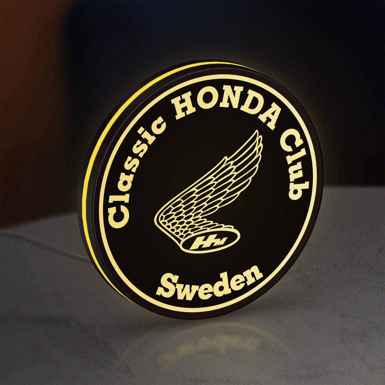 Classic Honda Racing Club LED lightbox standing on a desk from an angled side view with yellow glow