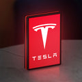 Tesla LED lightbox standing on a desk from an angled side view with red glow