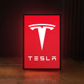 Front view of Tesla LED lightbox sign glowing on a wooden desk