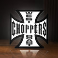 Front view of West Coast Choppers LED lightbox sign glowing on a wooden desk