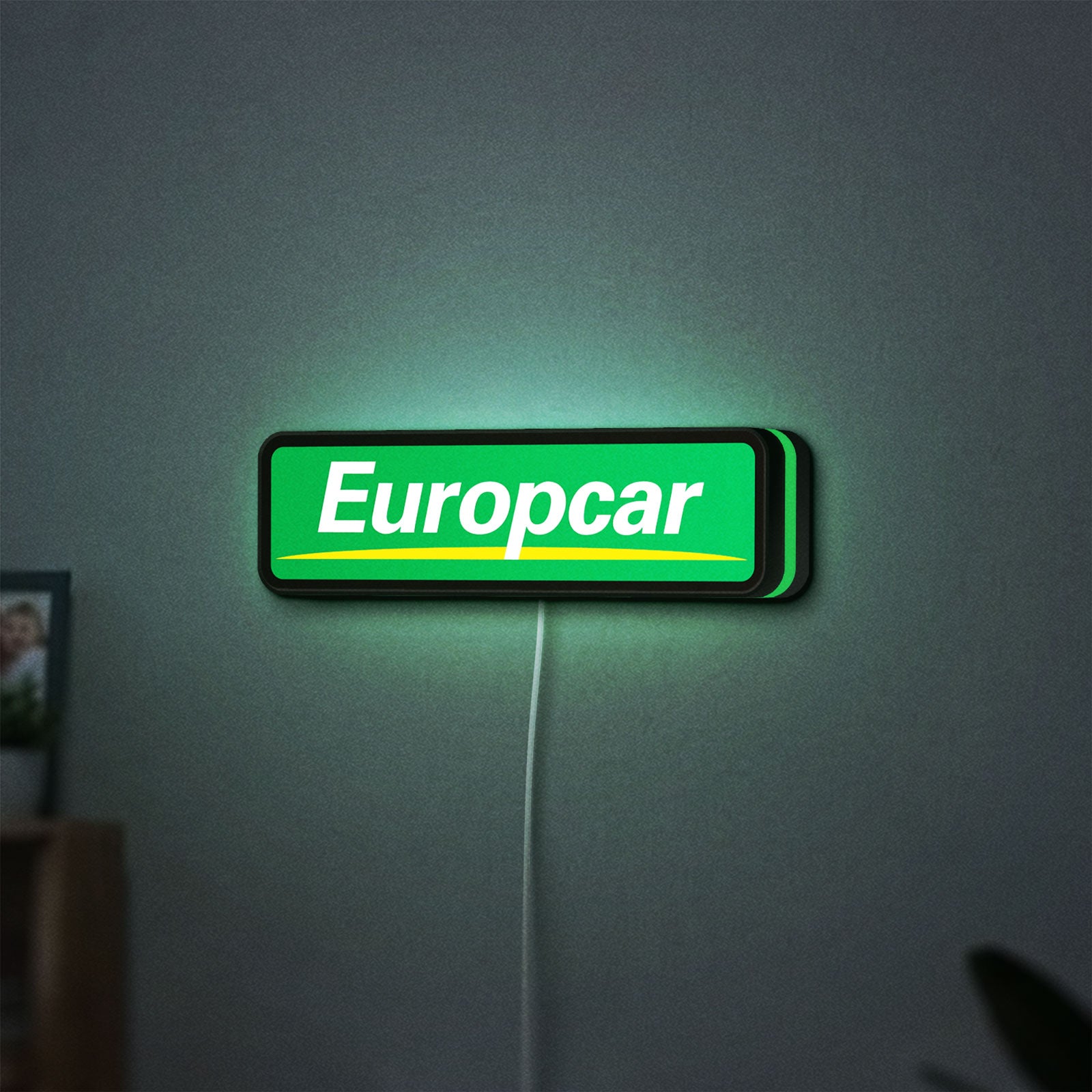 Europcar Sign LED lightbox hanging on a wall with green glow