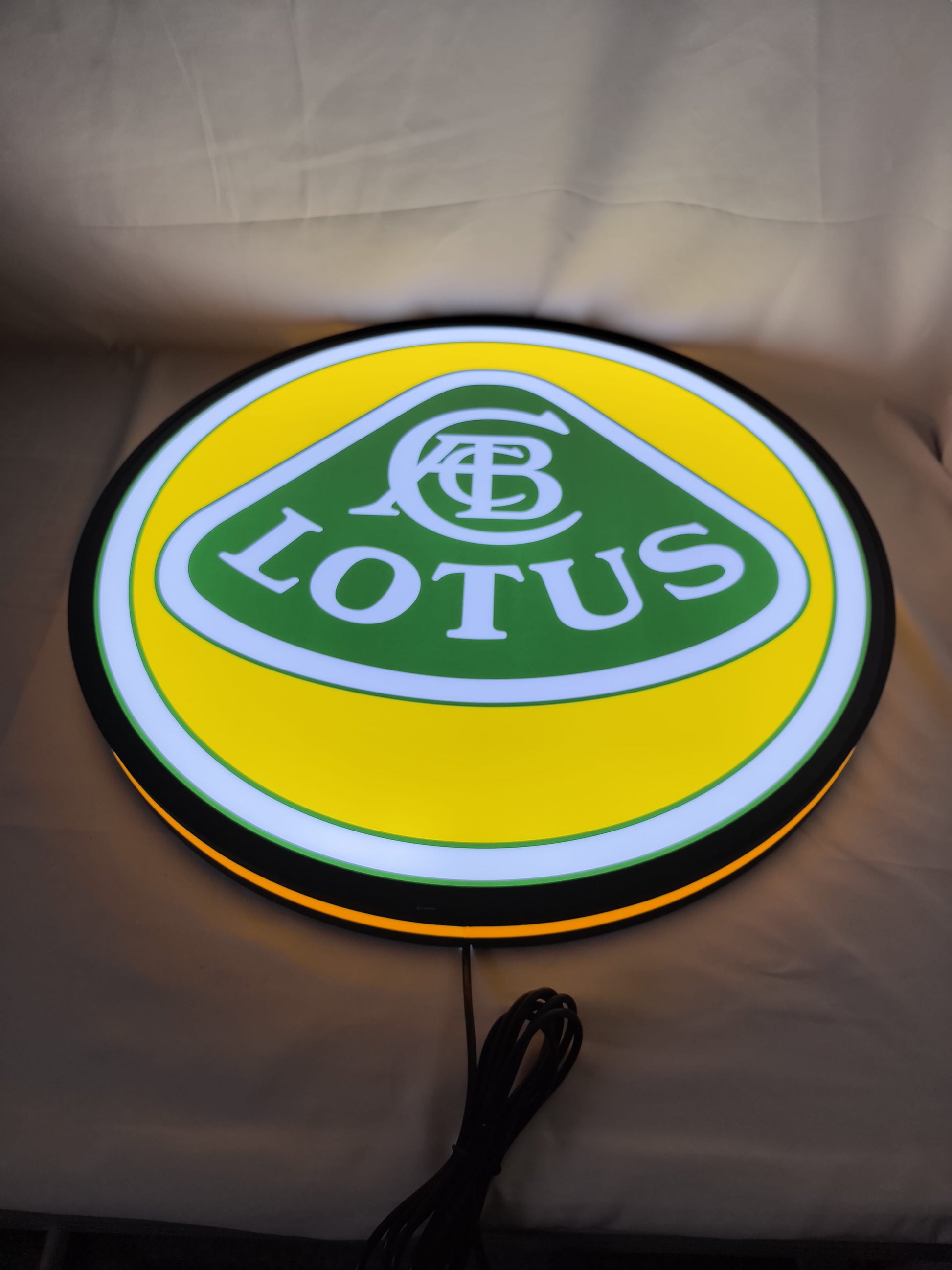 Illuminated flat lay angled view of Lotus Cars 3D LED Sign in 50cm, perfect for garage and man cave decor