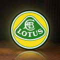 Front view of Lotus Cars LED lightbox sign glowing on a wooden desk