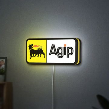Agip Six-Legged Dog LED lightbox hanging on a wall with yellow glow