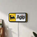 Unlit Agip Six-Legged Dog LED lightbox mounted on a wall in daylight