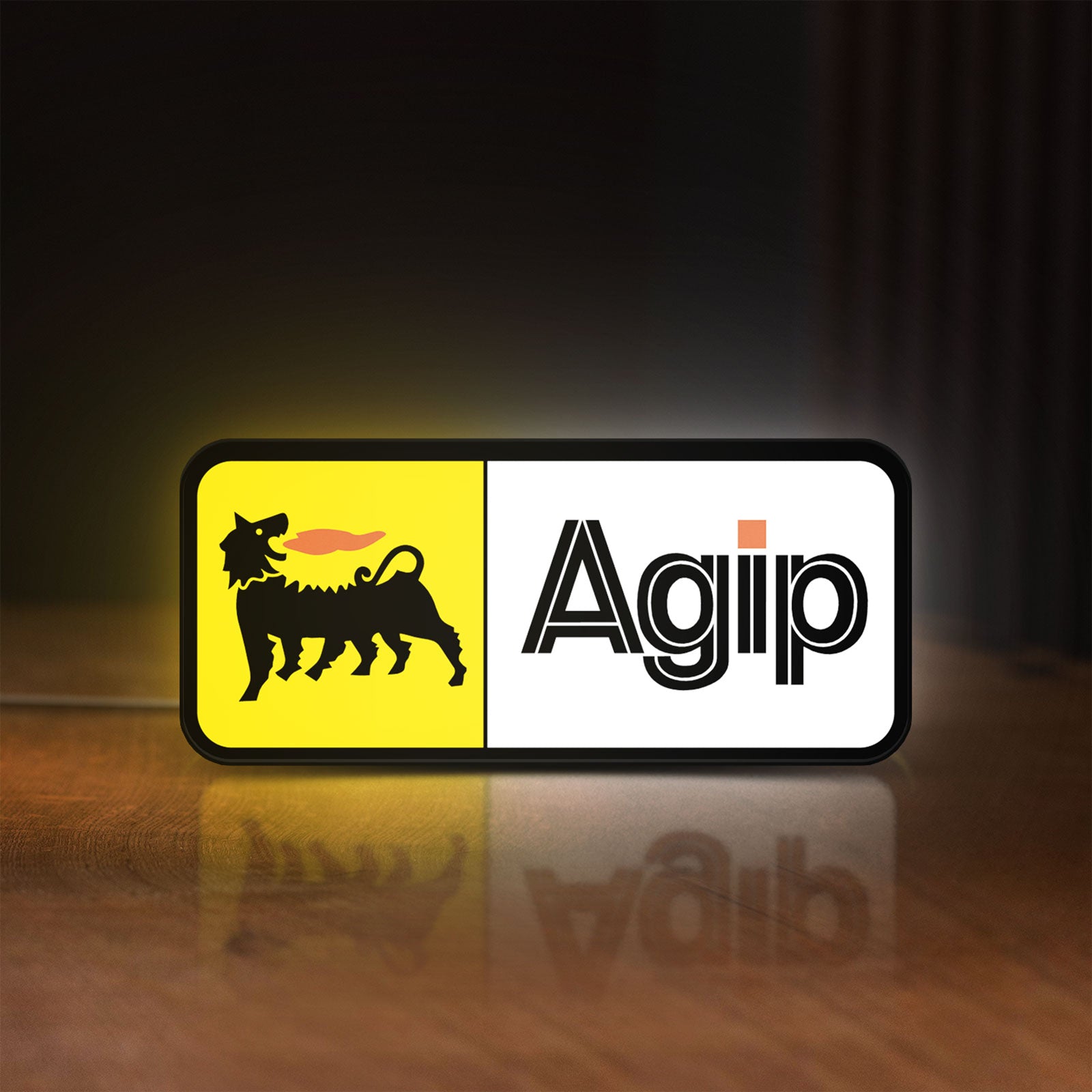 Front view of Agip Six-Legged Dog LED lightbox sign glowing on a wooden desk