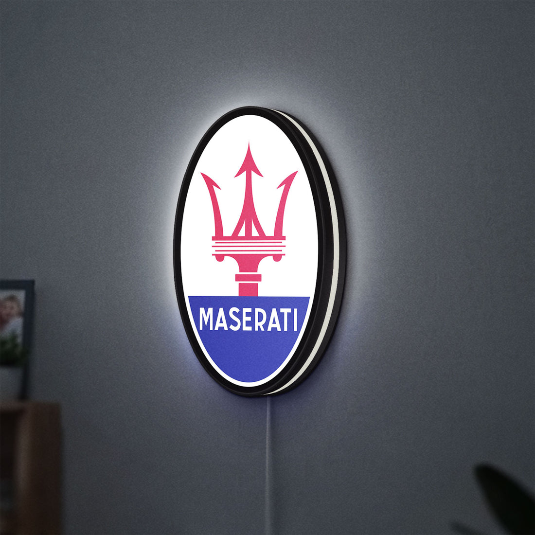 Maserati LED lightbox hanging on a wall with white glow