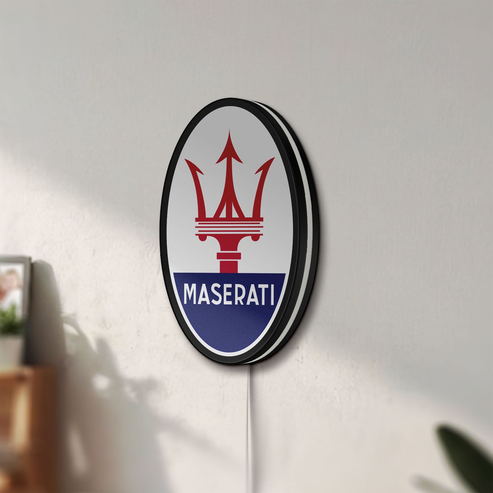 Unlit Maserati LED lightbox mounted on a wall in daylight