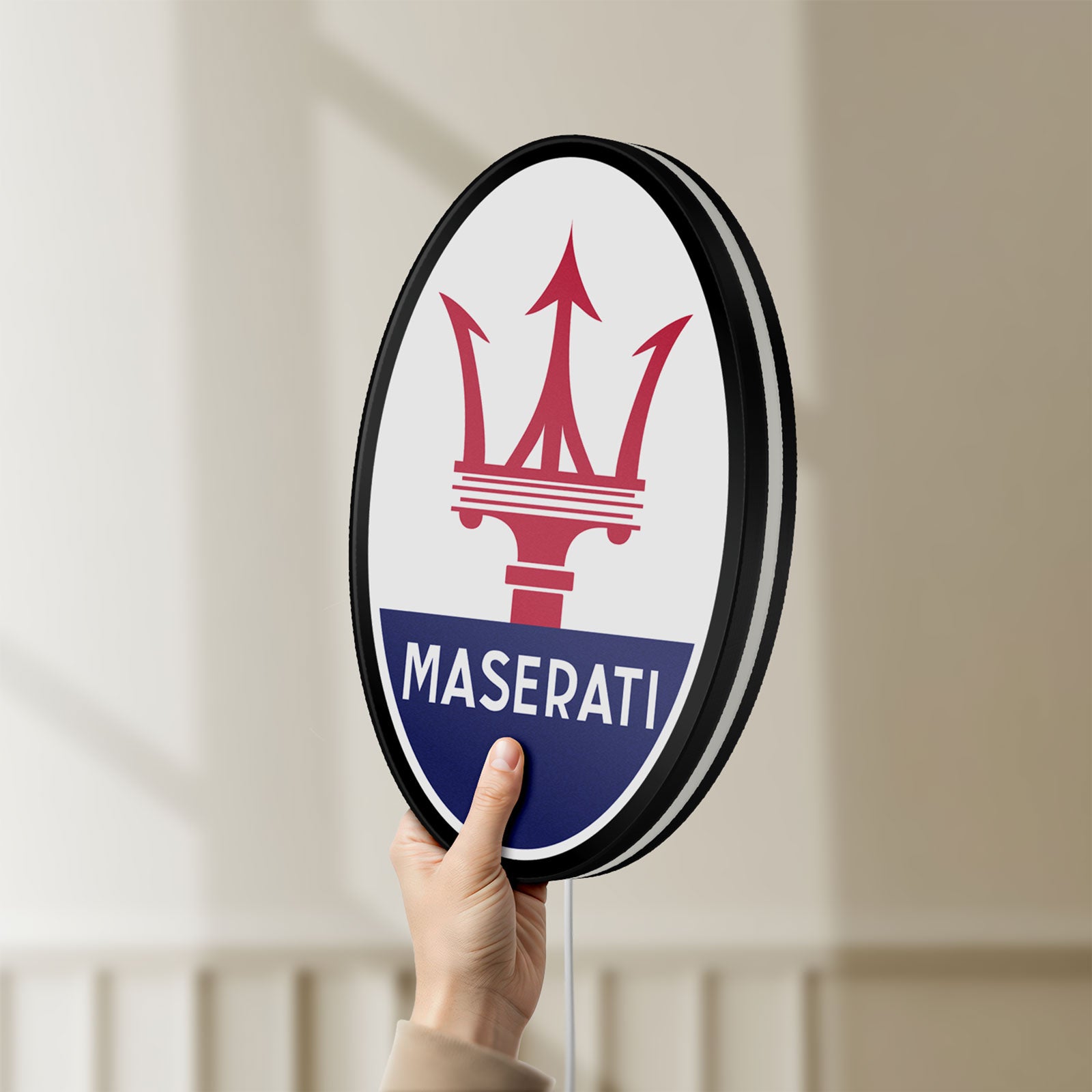 Unlit Maserati LED lightbox held by hand to show size and details