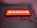 Gasgas LED Sign (50cm) - Illuminated flat lay angled view, unique wall art for desk and room decor