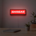 GasGas LED lightbox hanging on a room wall with soft red light