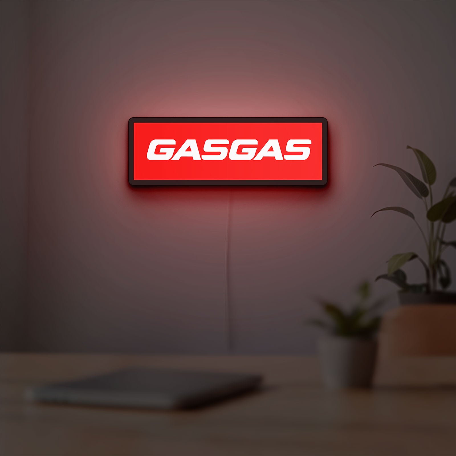 GasGas LED lightbox hanging on a room wall with soft red light