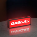 GasGas LED lightbox standing on a desk from an angled side view with red glow