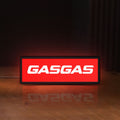 Front view of GasGas LED lightbox sign glowing on a wooden desk