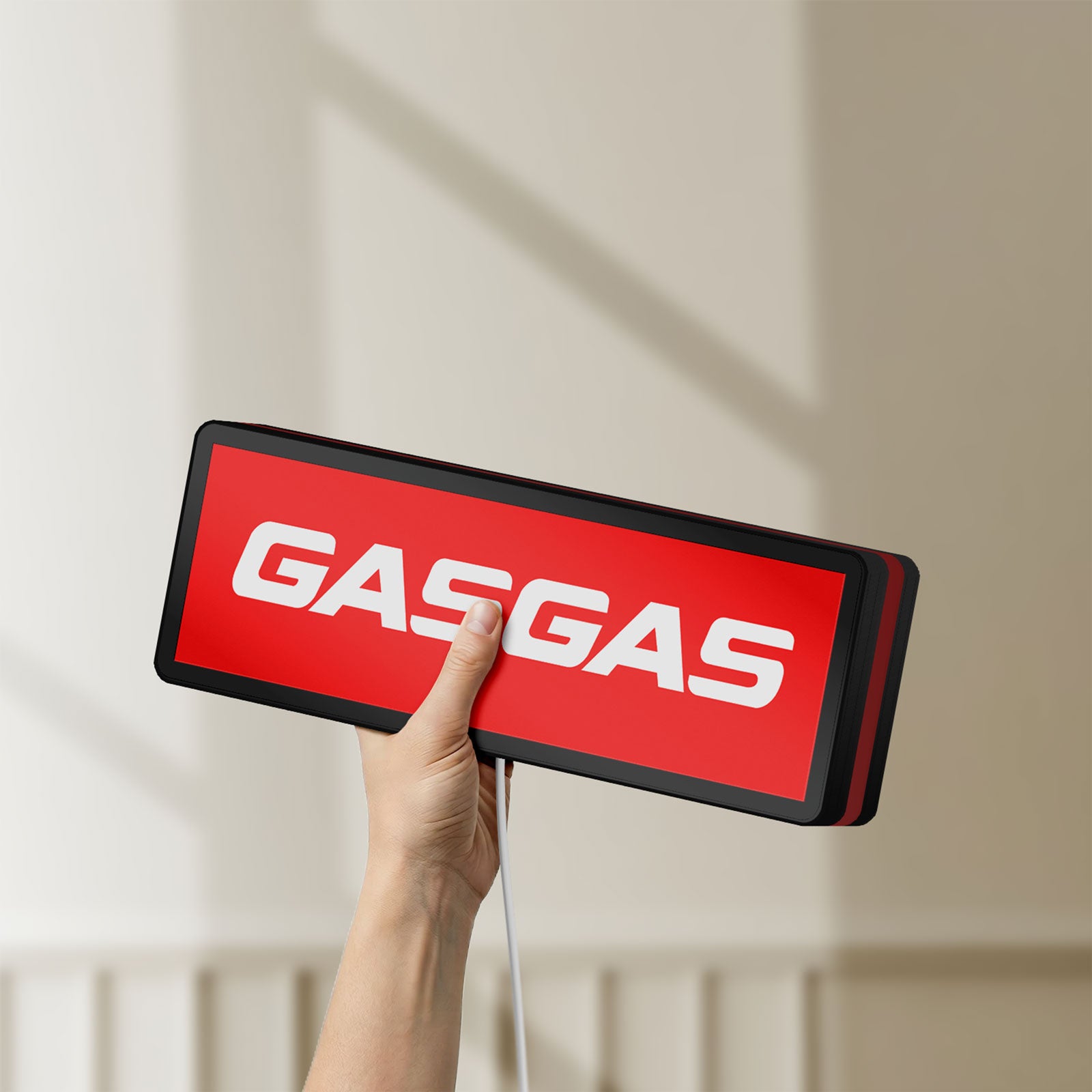 Unlit GasGas LED lightbox held by hand to show size and details