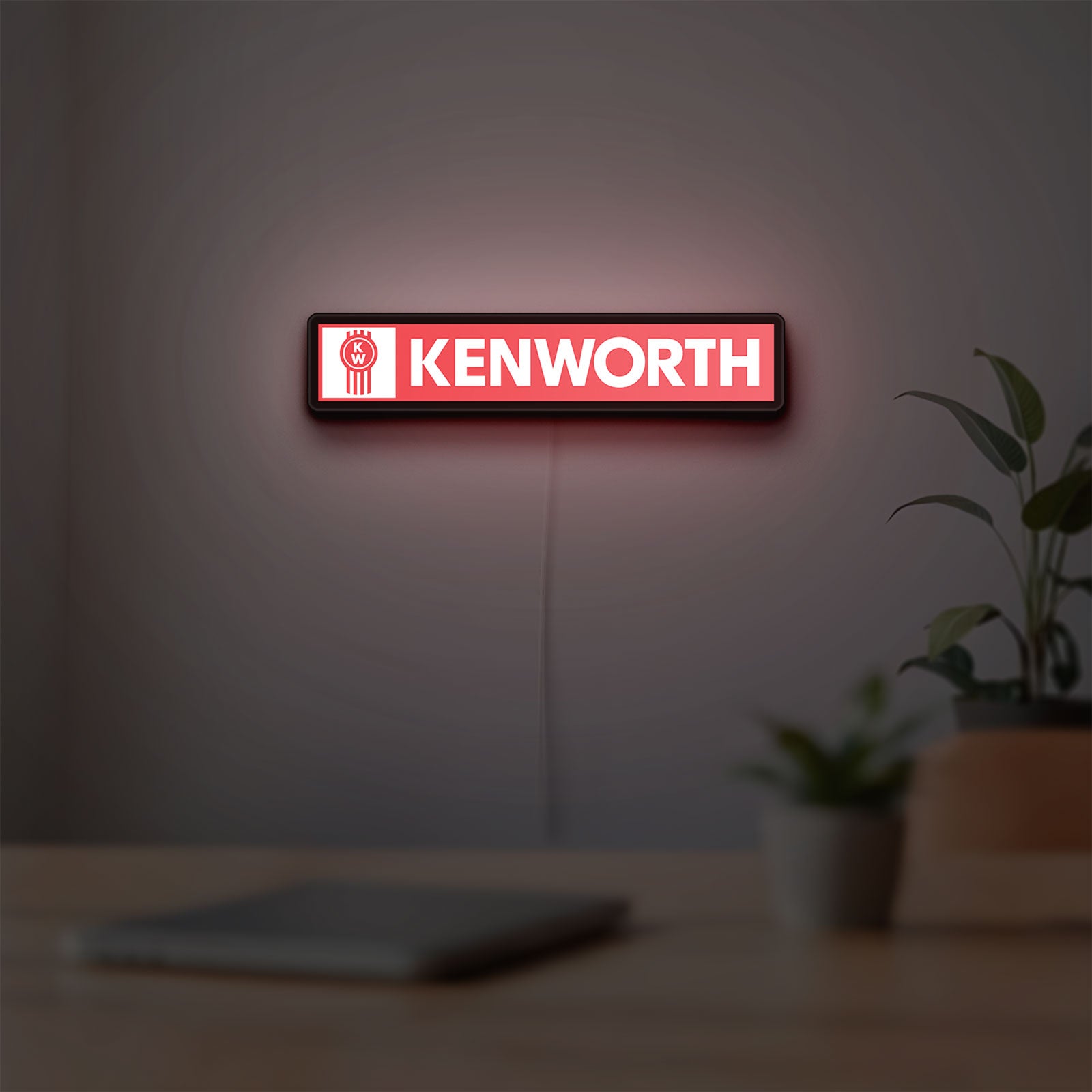 Kenworth LED lightbox hanging on a room wall with soft red light