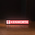 Front view of Kenworth LED lightbox sign glowing on a wooden desk