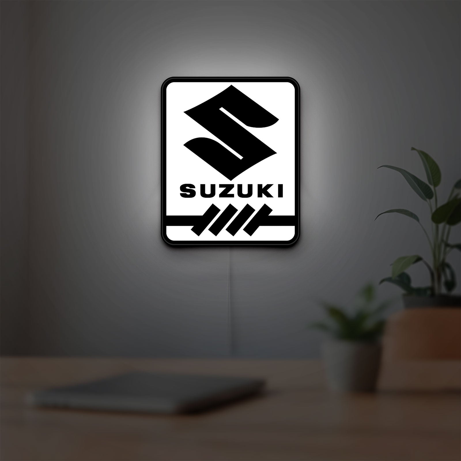 Suzuki LED lightbox hanging on a room wall with soft white light