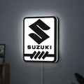 Suzuki LED lightbox hanging on a wall with white glow