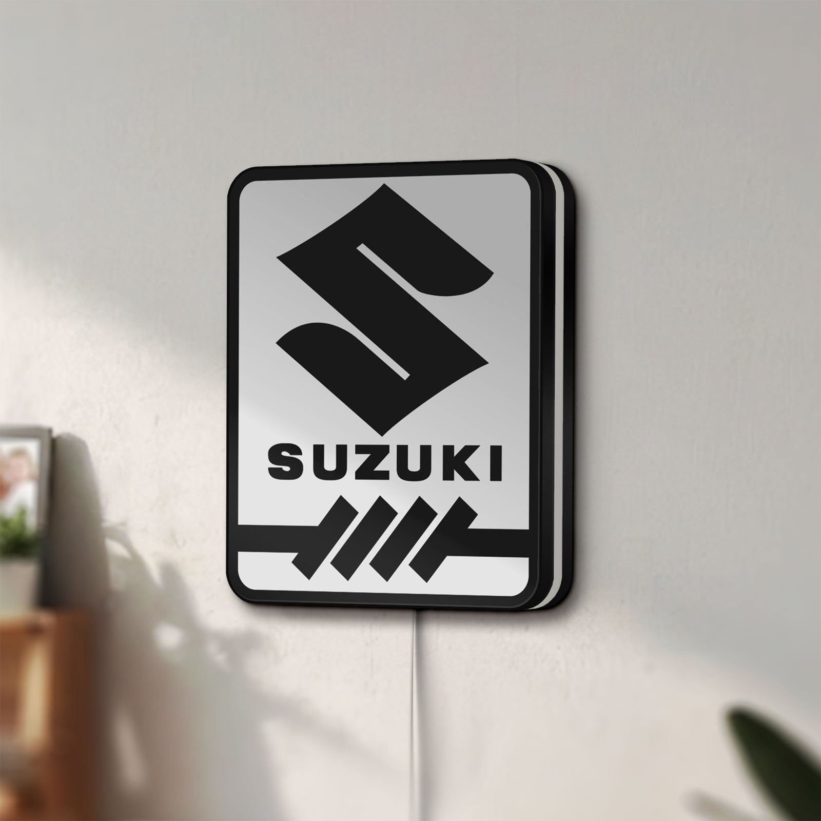 Unlit Suzuki LED lightbox mounted on a wall in daylight