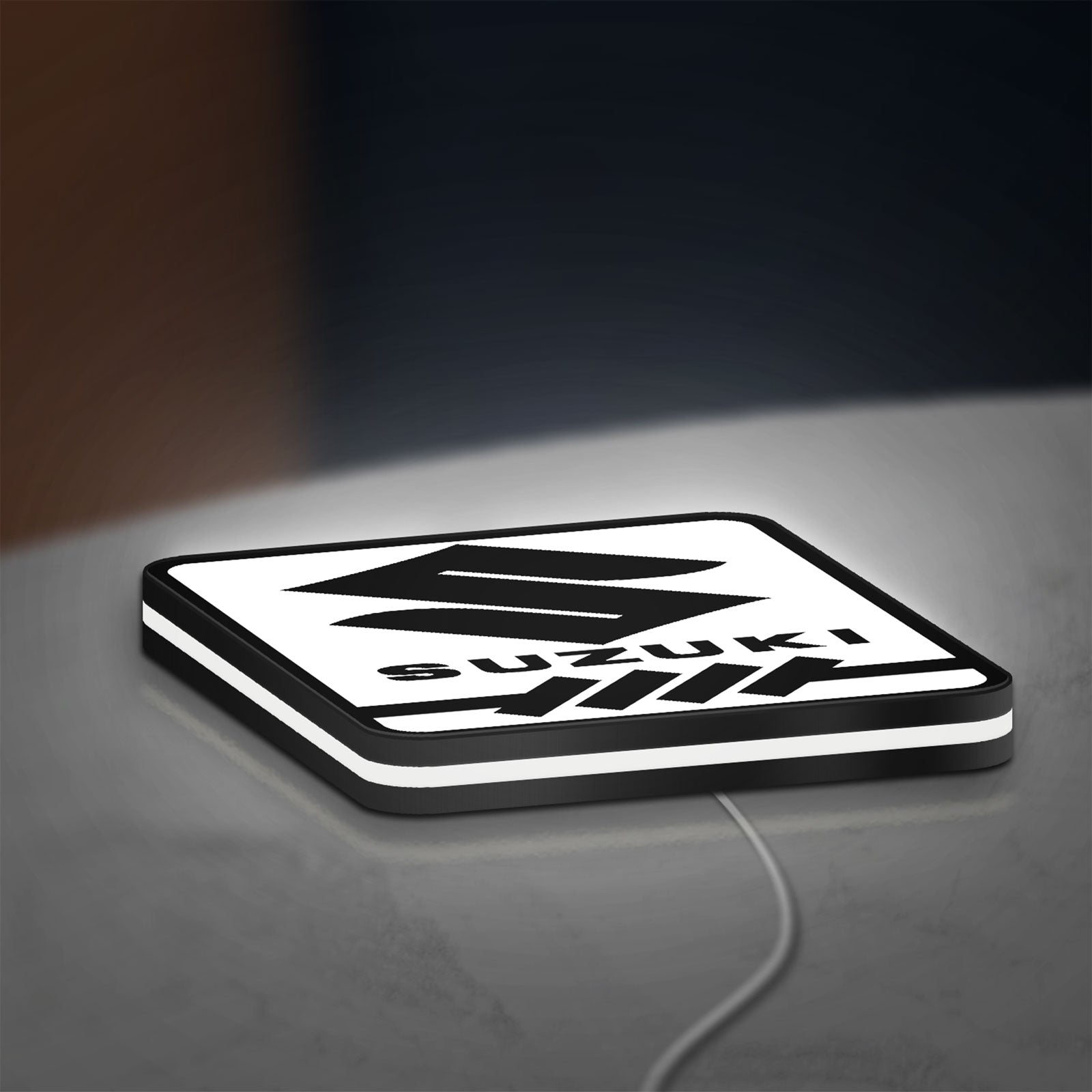 Suzuki LED lightbox lying flat on a desk with white glow