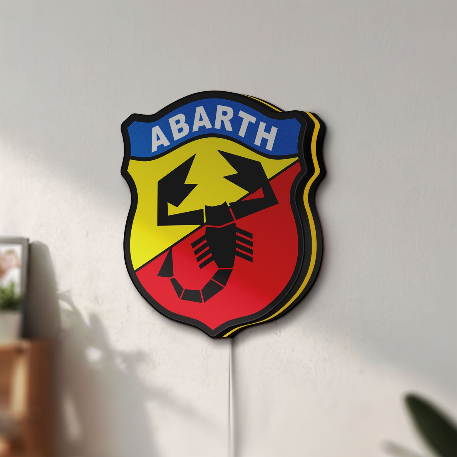Unlit Abarth Scorpion LED lightbox mounted on a wall in daylight