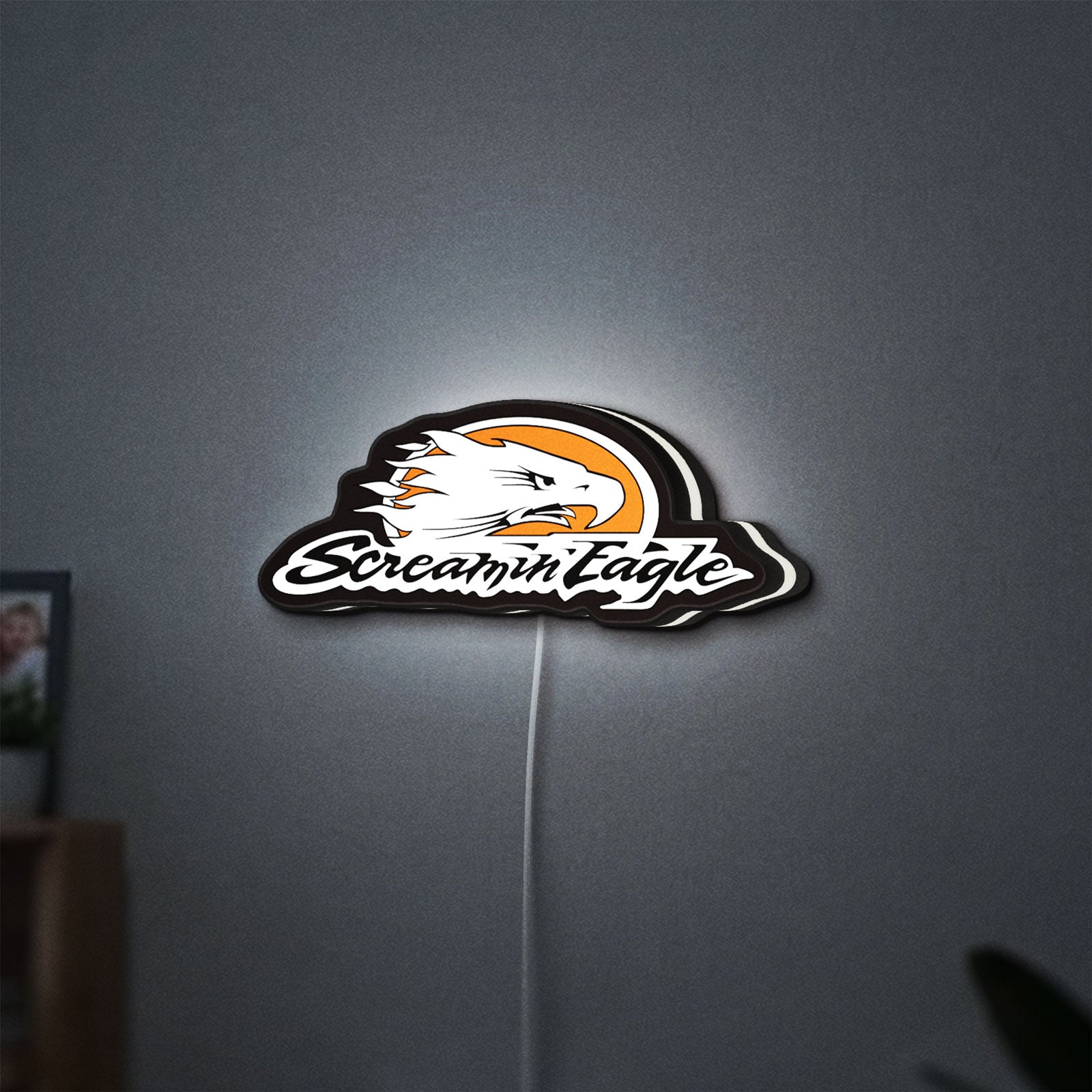 Screamin Eagle LED lightbox hanging on a wall with white glow