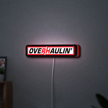 Overhaulin LED lightbox hanging on a wall with red glow