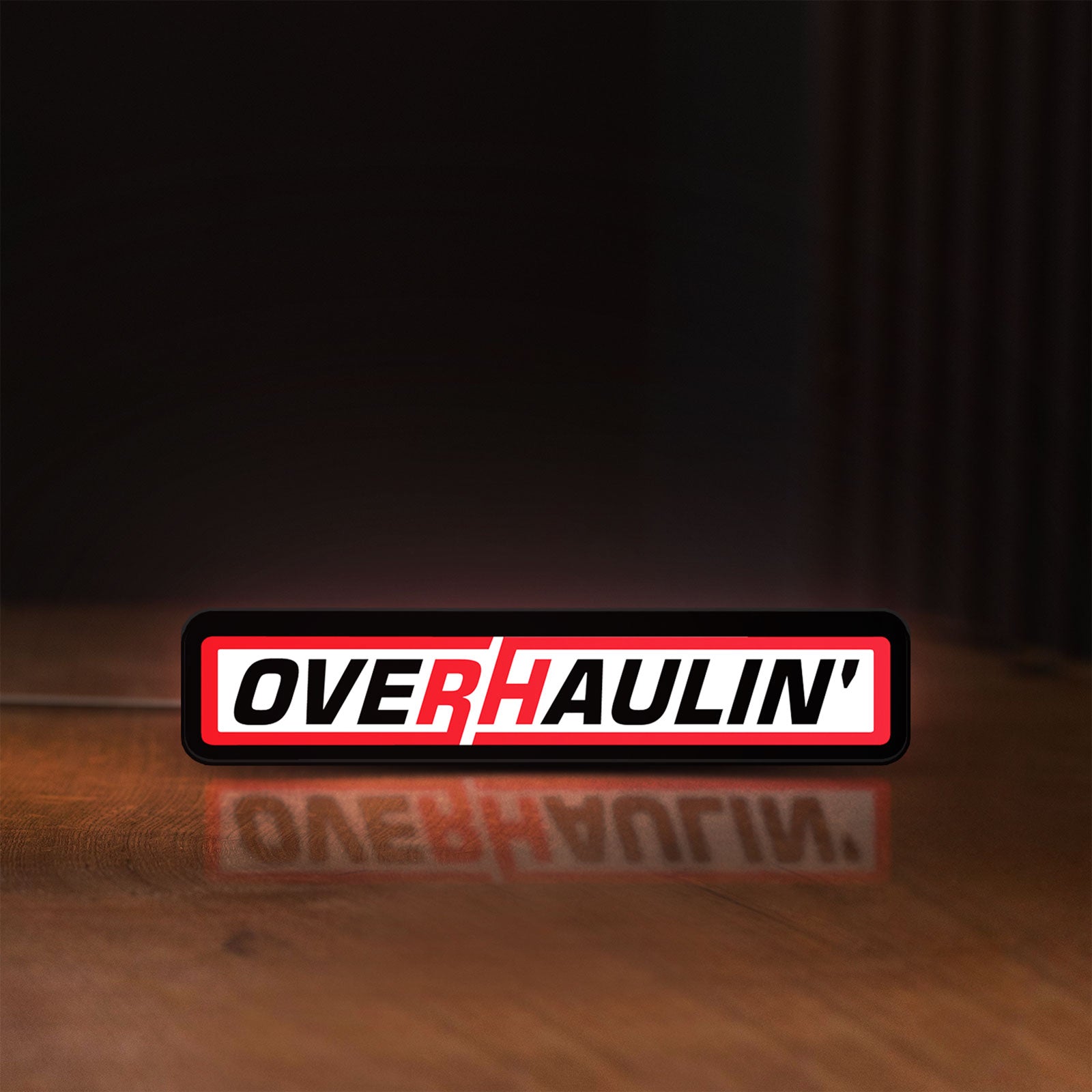 Front view of Overhaulin LED lightbox sign glowing on a wooden desk